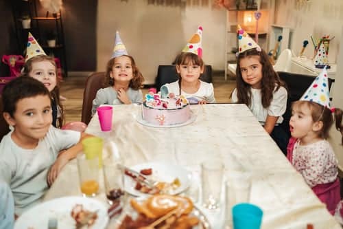 Freunde mit Partyhüten beim zehnten Kindergeburtstag in Stuttgart